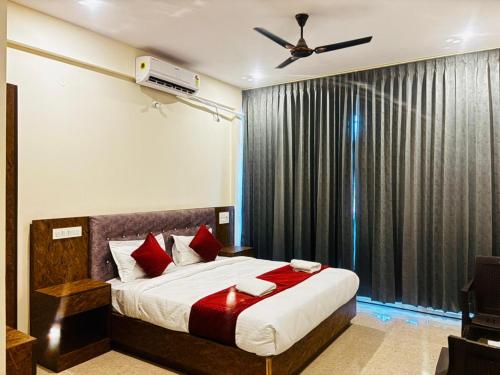 a bedroom with a bed and a ceiling fan at Surabhi Comforts Inn in Mysore