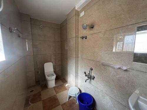 a bathroom with a shower with a toilet and a sink at Surabhi Comforts Inn in Mysore