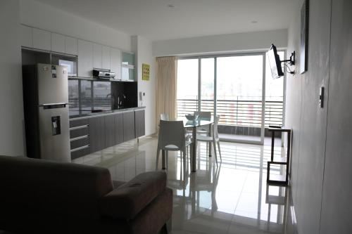 a kitchen with a refrigerator and a table with chairs at Terrazas Apartments Miraflores in Lima