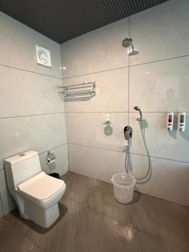 a bathroom with a toilet and a shower at Orange Sky Inn in Canacona
