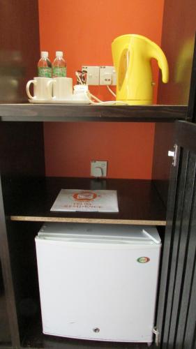 a shelf with a white refrigerator under a counter at Hotel Felda Residence Hot Springs in Sungkai