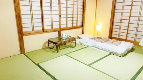 a room with a bed and a table in it at 富士見旅館101 in Fujiyoshida