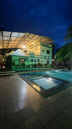 a large building with a swimming pool at night at Classy Stay Villa - Karjat in Dhamni