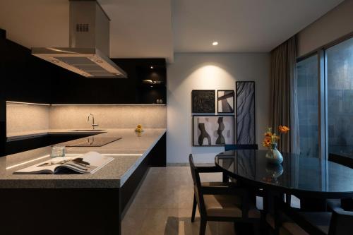 a kitchen with a table and a dining room at AYANA Segara Bali in Jimbaran