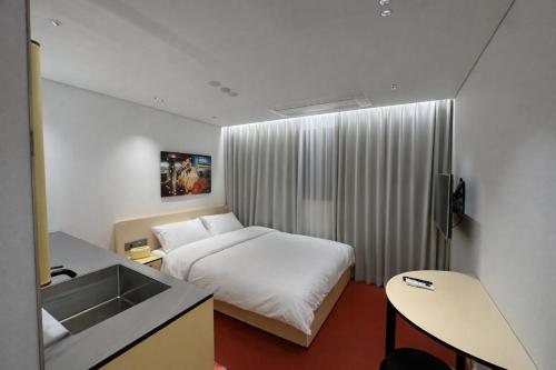 a hotel room with a bed and a sink at Fritta Hotel in Suwon