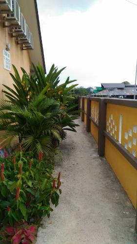 a walkway next to a building with plants at Tokman Inn in Pantai Cenang