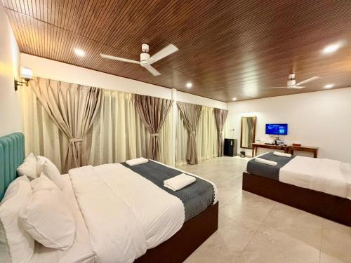 a bedroom with two beds and a tv in it at Orange Sky Inn in Canacona