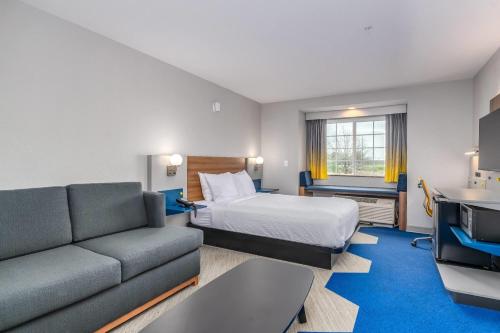 a hotel room with a bed and a couch at Microtel Inn & Suites by Wyndham Montgomery in Mitylene