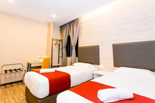 a hotel room with two beds and a desk at Icon Hotel Segamat in Segamat