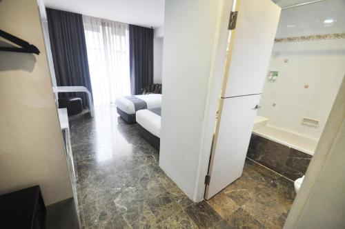 a hotel room with a bed and a bathroom at Dreamtel Jakarta in Jakarta