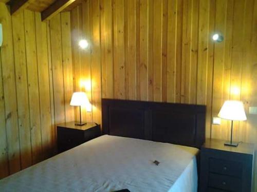 una camera da letto con un letto con due lampade sopra di Casa da Corga a Portela