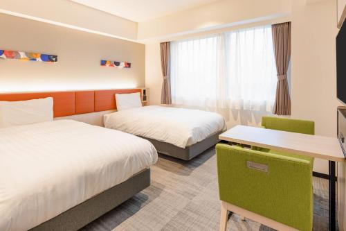 a hotel room with two beds and a desk at Comfort Hotel Kyoto Horikawagojo in Kyoto