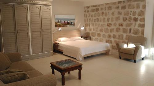 a bedroom with a bed and a couch and a table at Stone House Petra in Perast