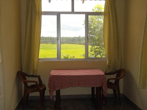 a table and two chairs in front of a window at Sunset Tourist Home in Polonnaruwa