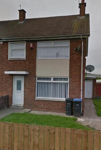 a brick house with a fence in front of it at Pallister House Middlesbrough in Middlesbrough