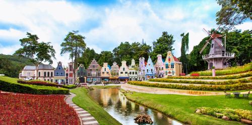 a large building with a pond in a park at Brookside Valley Resort in Rayong