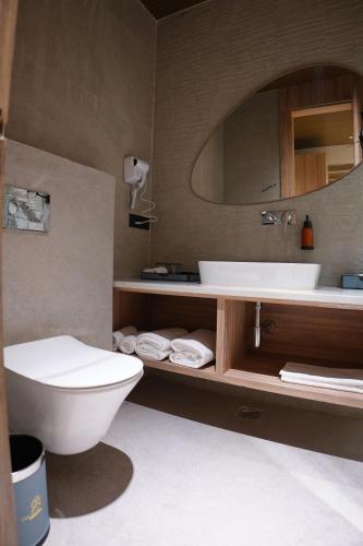 a bathroom with a sink and a toilet and a mirror at The Pearl Petal in Rohtak