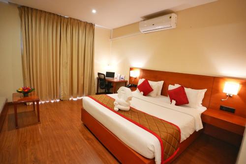 a hotel room with a bed with a teddy bear on it at The Altruist Hitech Hotel in Hyderabad