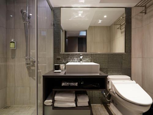 a bathroom with a toilet and a sink and a shower at At Home Hotel Ximen in Taipei