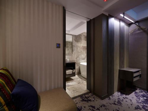 a bathroom with a tub and a toilet and a sink at At Home Hotel Ximen in Taipei