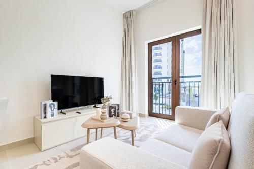 a living room with a couch and a tv at Charming Studio next 5 min walk to Formula 1, Golf Course, and Yas Water World in Abu Dhabi