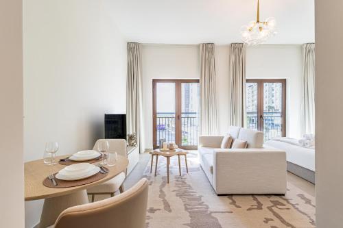 a white living room with a couch and a table at Charming Studio next 5 min walk to Formula 1, Golf Course, and Yas Water World in Abu Dhabi
