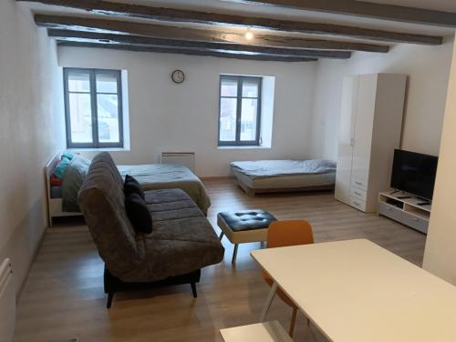 a living room with a couch and a bed at Hébergements Sylvain in Neuilly-lʼÉvêque