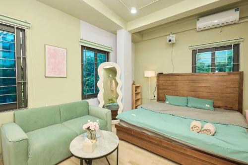 a bedroom with a bed and a couch and a table at Trên Mây HST - 91 Cầu Diễn in Văn Trì