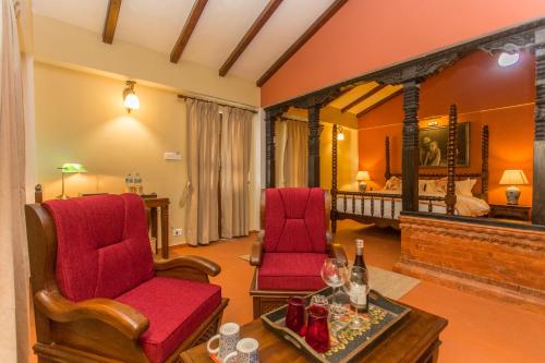 a living room with two chairs and a table at Baber Mahal Vilas - The Heritage Hotel in Kathmandu