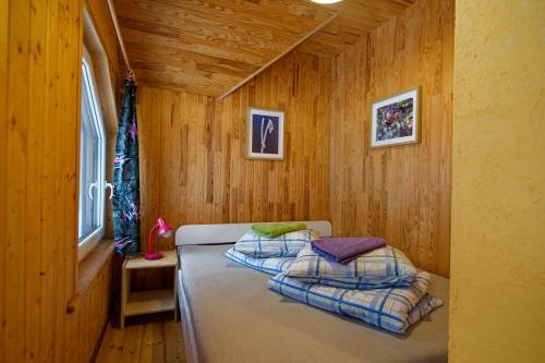 a bedroom with a bed in a wooden room at Atpūtas vieta Upes Sausītes in Sidrabiņi