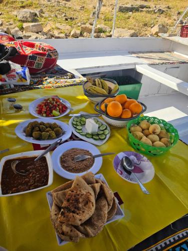 a table with food on a yellow table cloth at Aswan all-inclusive private felucca in Aswan