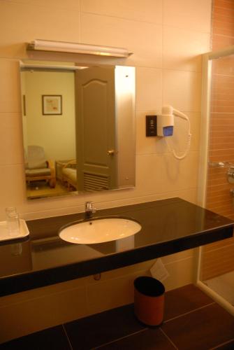 a bathroom with a sink and a mirror at The Pavilion Hotel in Sandakan