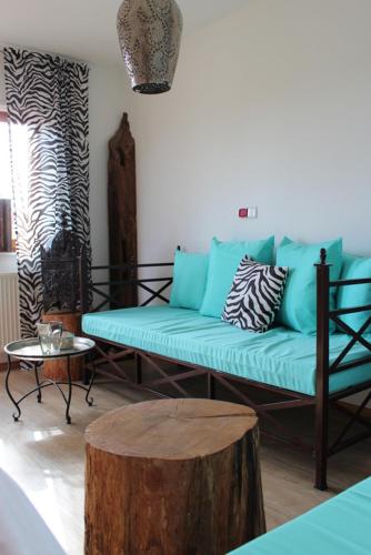 a living room with a blue couch and a tree stump at Wohnen im orientalischen Ambiente in Harthausen