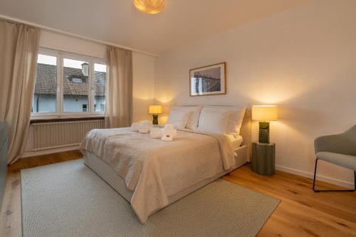a bedroom with a bed with two lamps and a chair at Cocoa Suite · Kilchberg in Kilchberg
