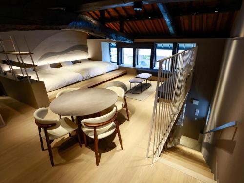 a bedroom with a bed and a table and chairs at The 曜 Terrace in Hirado