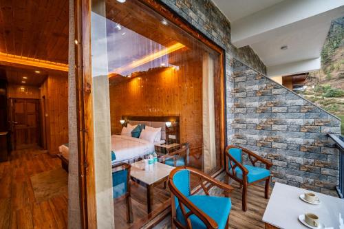 a room with a bed and a table and chairs at Vedikant Pine Tree Resort in Chail