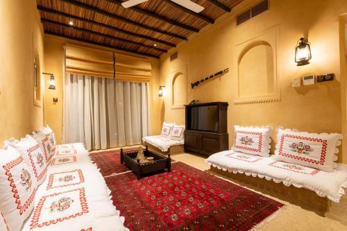 a living room with two white couches and a red rug at The Luxe Retreat Hotel Apartments in Dubai