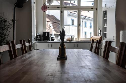 a dining room table with a vase on top of it at B&B im Herzen von Biel in Biel