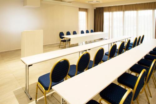 a lecture room with chairs and tables and a podium at Hotel Navis in Orašje