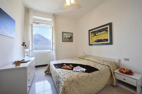1 dormitorio con cama, escritorio y ventana en Bella Varenna, en Varenna