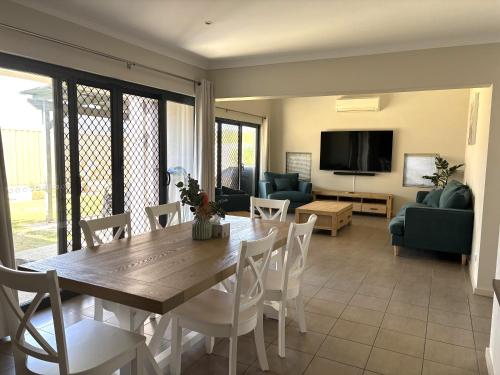 a dining room with a table and chairs and a living room at Cozy On Chapman in Geraldton