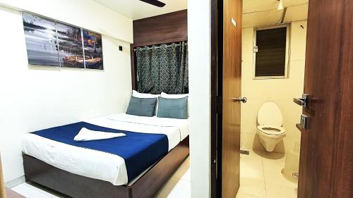 a bedroom with a bed and a bathroom with a toilet at Hotel Express Airoli in Navi Mumbai
