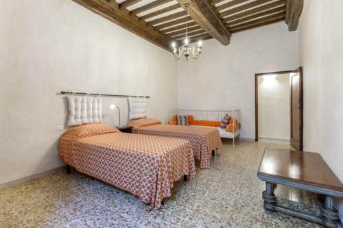 a room with three beds and a table in it at Terrazza a Campana in Panzano