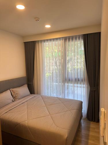 a bedroom with a large bed and a large window at Laguna SkyPark in Laguna Phuket