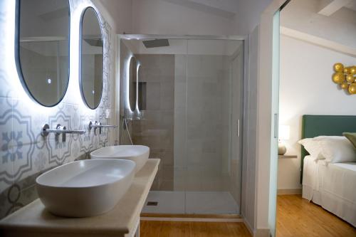a bathroom with two sinks and a shower at Luxury B&B Maison Madre in the historic center of Avola in Avola