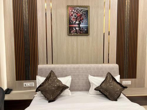 a bedroom with a bed with black and white pillows at Hotel Highway Retreat in Gajraula