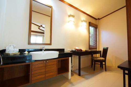 a bathroom with a sink and a mirror at Aonang Phu Petra Resort, Krabi - SHA Plus in Ao Nang Beach