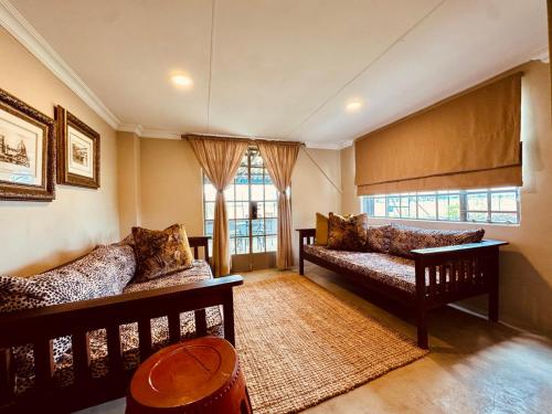 a living room with two couches and a window at The Grove in Potchefstroom
