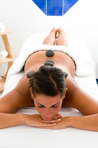a pregnant woman laying on a bed with balances on her back at Hotel La Villarosa Terme in Ischia