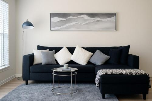 a blue couch in a living room with a table at Stunning 1BR near The Heights with BBQ, Gym & Pool in Houston